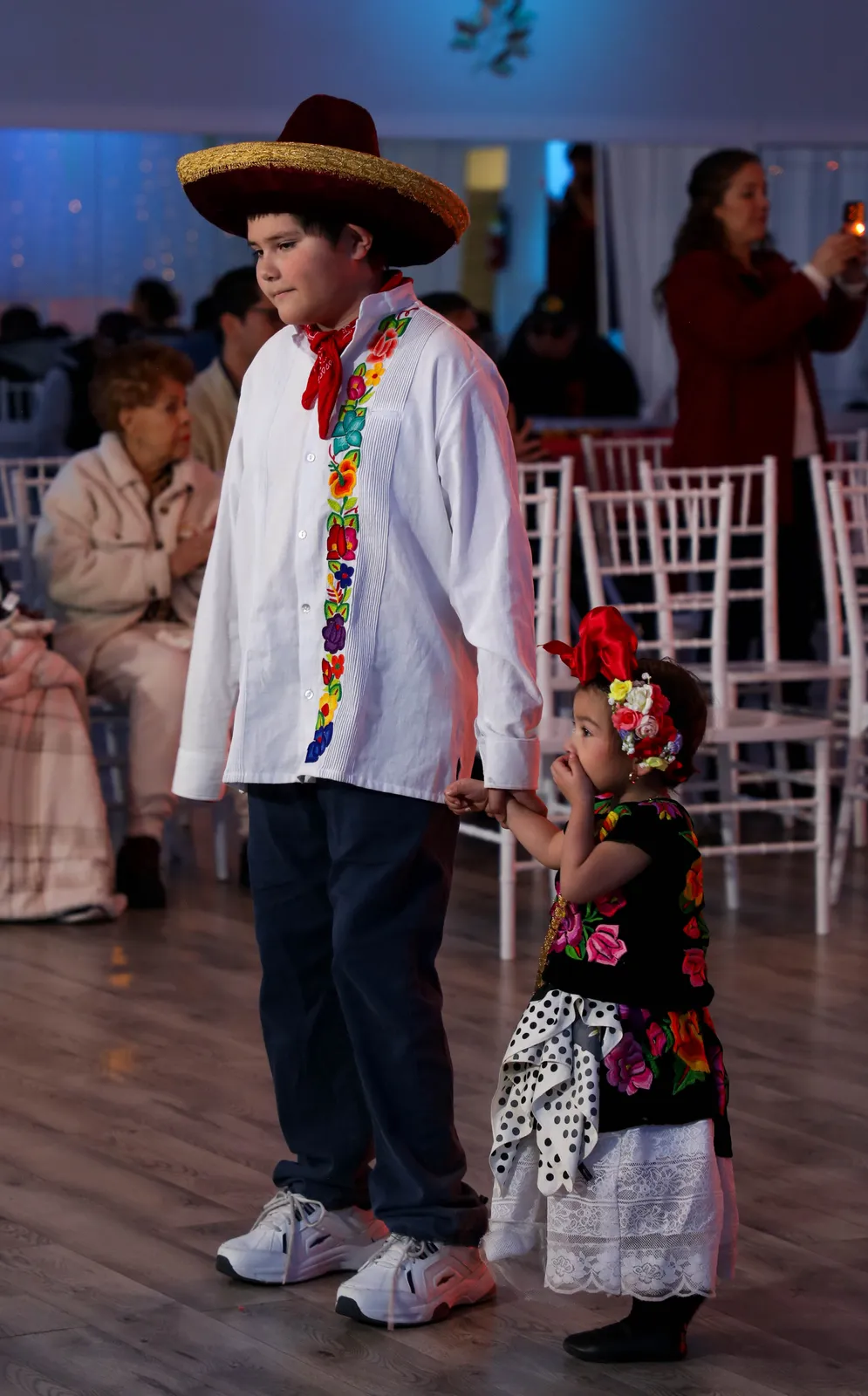 White floral embroidered shirt, neck scarf, dark trousers, and broad-brimmed hat at Oaxaca en Utah’s Fashion Show 2025