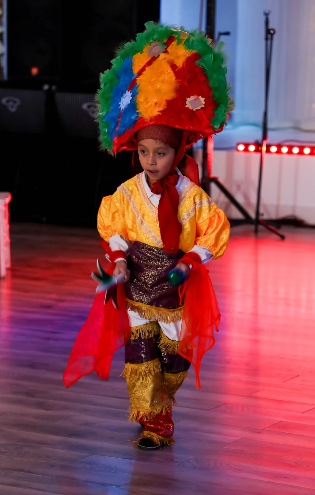 Danza de la Pluma clothing with a multicolored semicircular feather headdress at Oaxaca en Utah’s Fashion Show 2025