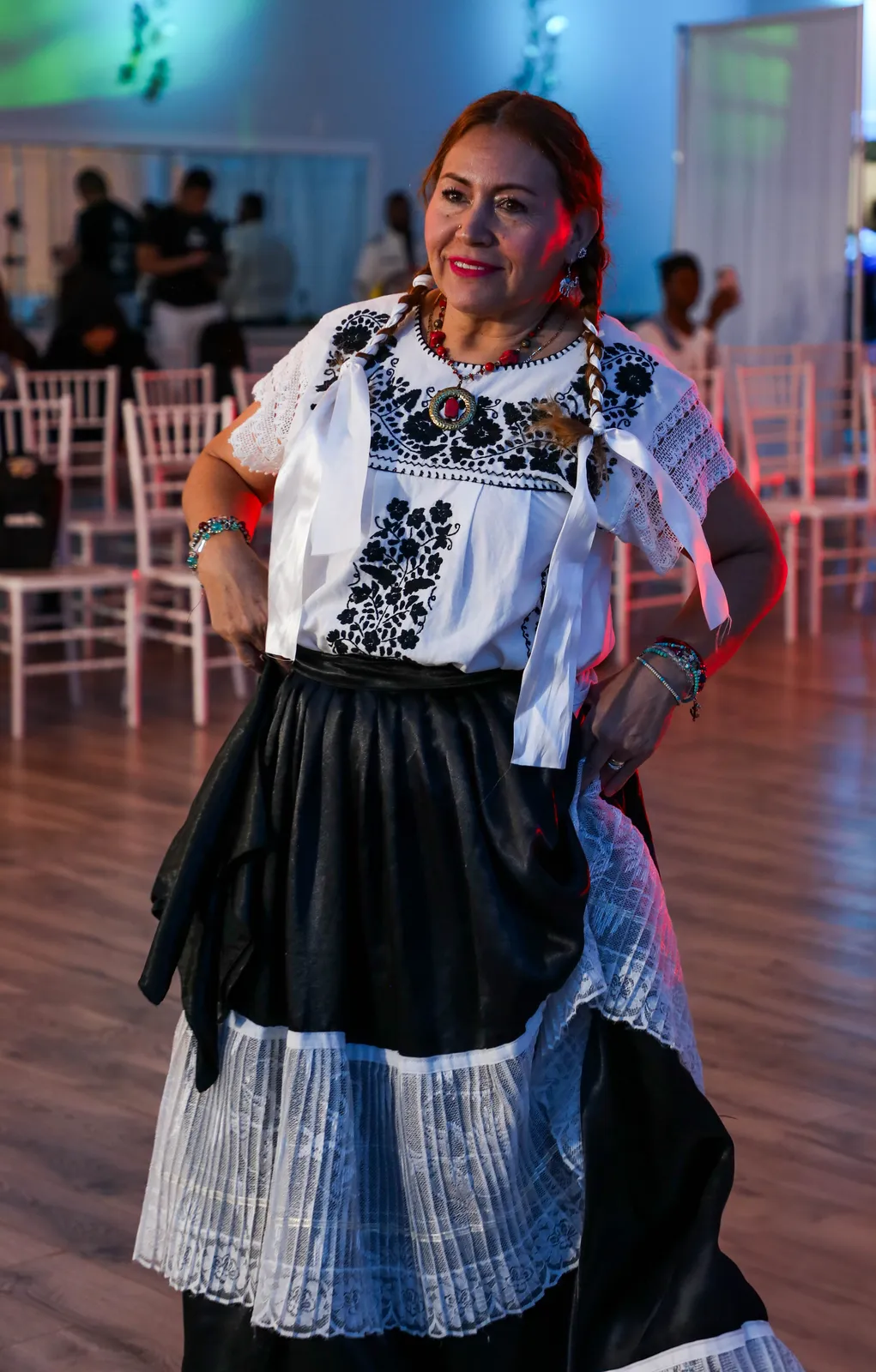 White blouse with black floral embroidery and black skirt with a wide white lace band at Oaxaca en Utah’s Fashion Show 2025