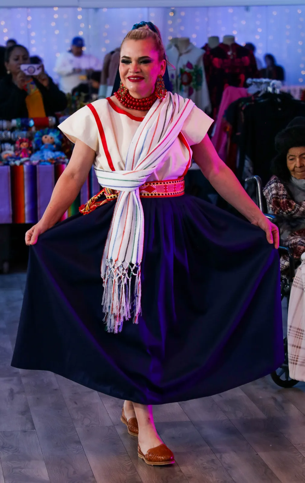 Indigo skirt, white blouse with red trim, woven sash, and striped white rebozo at Oaxaca en Utah’s Fashion Show 2025