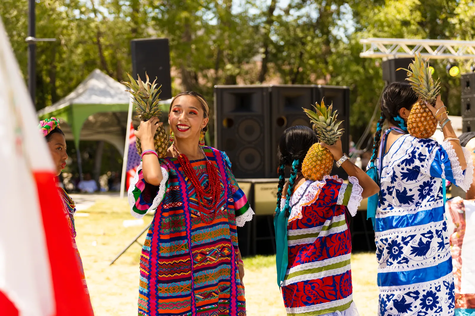 Flor de Piña dancers hold pineapples beside their faces at La Guelaguetza 2026