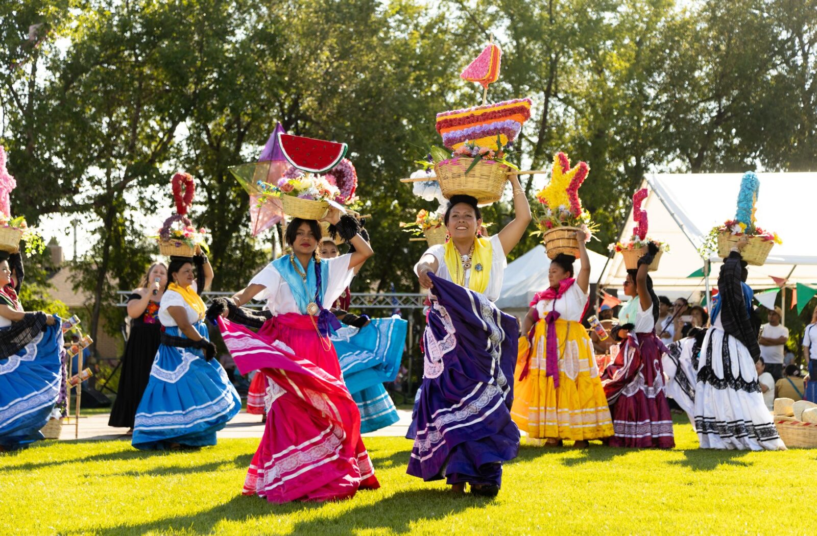 Young Oaxaca en Utah dancers performing in traditional white dresses at La Guelaguetza