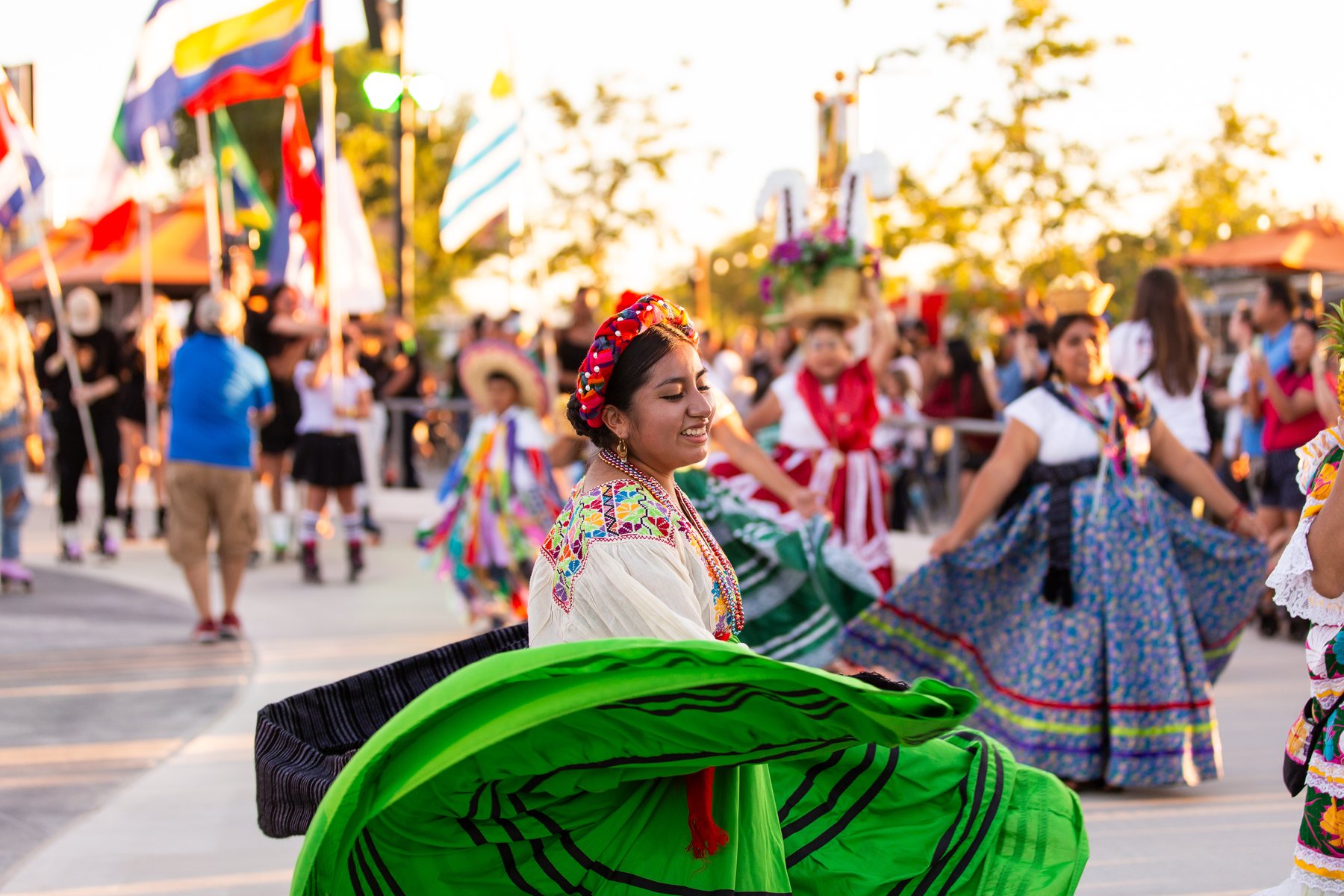 Una participante con falda verde gira por el área de presentación al aire libre
