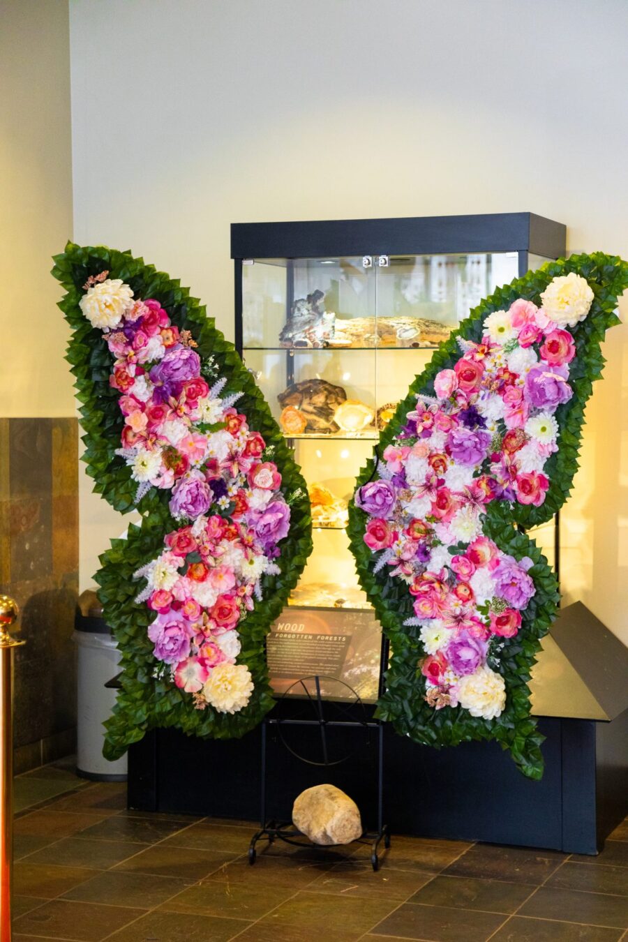 Una decoración floral en forma de corazón se encuentra junto a una exhibición de fósiles en Ogden Dinosaur Park