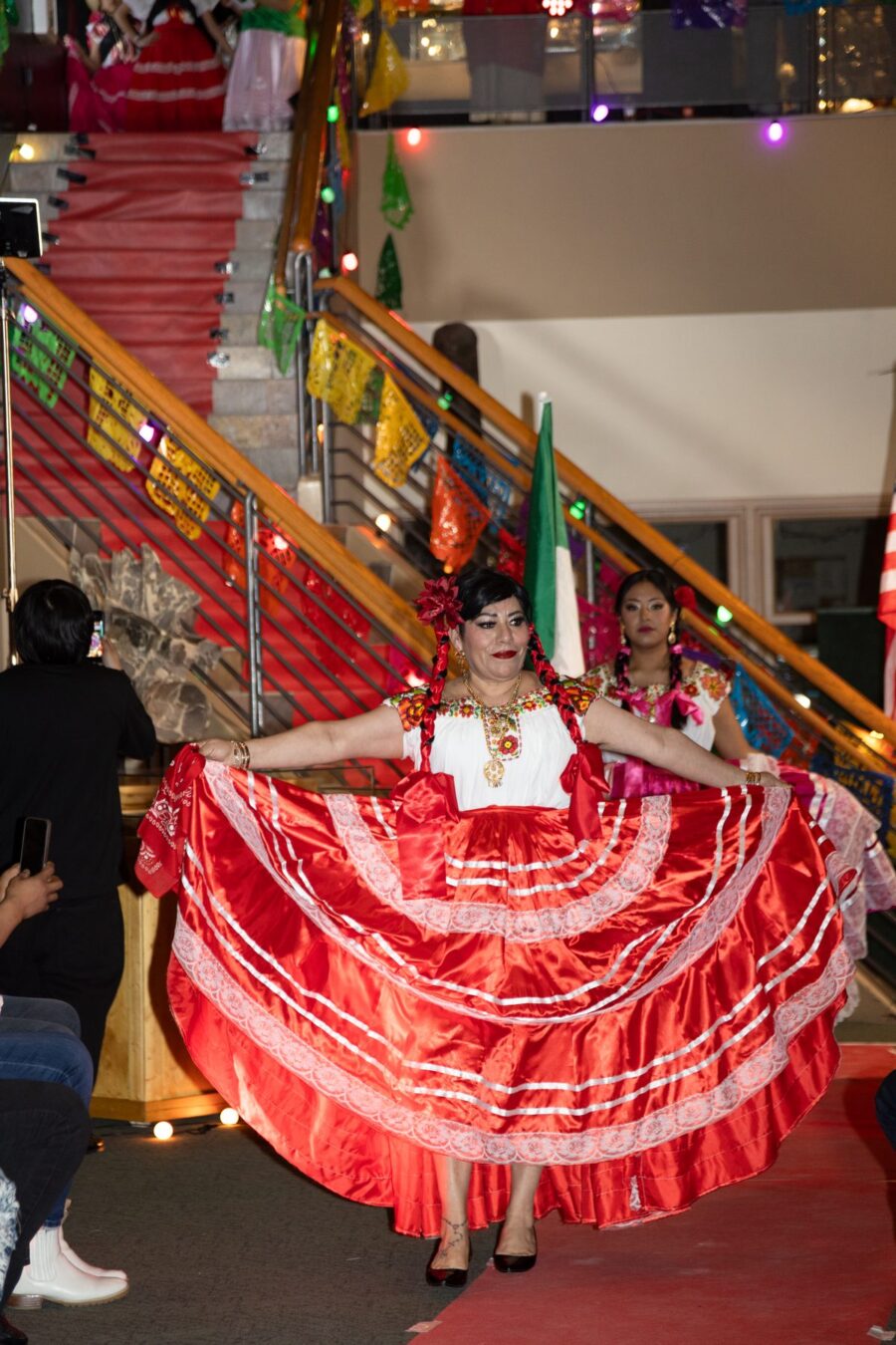 Una bailarina abre una falda roja brillante con encaje blanco mientras avanza por la pasarela