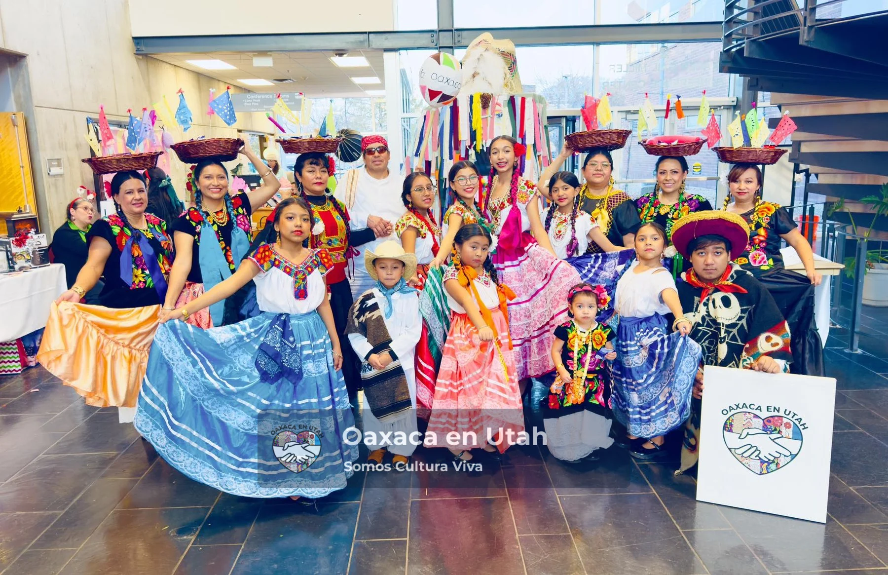 A large group in colorful clothing gathers for an indoor portrait