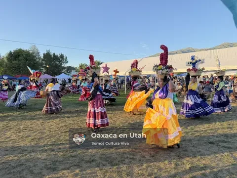 Chinas Oaxaqueñas in colorful skirts and floral baskets dance before the festival audience