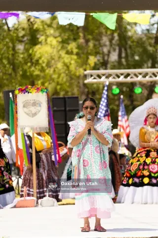Una bailarina con vestido blanco y bordado colorido se presenta en el escenario