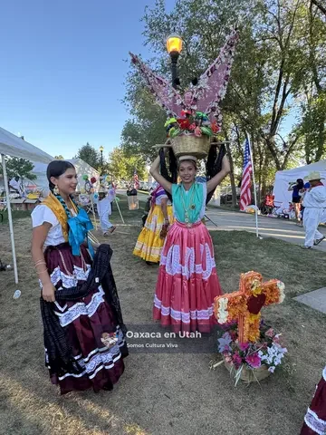 Young dancers pose with decorated floral baskets after performing at La Guelaguetza 2026