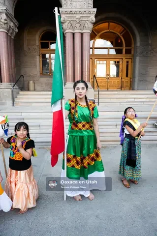 Participantes de Oaxaca en Utah se reúnen con una bandera de México en las escalinatas del edificio cívico