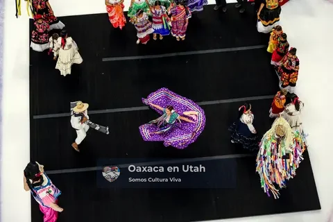 A participant turns a wide purple skirt at the center of the performance area