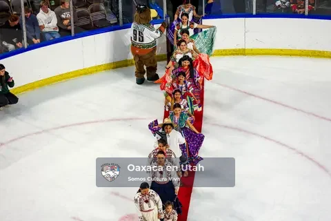 A single-file line of participants in colorful clothing crosses the ice on a red carpet