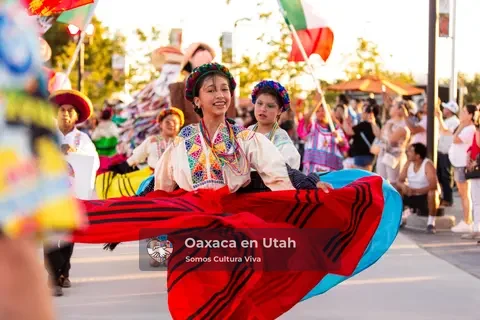 A participant extends a wide red skirt while others perform behind her