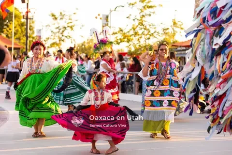 Women and girls move together in green, pink, blue, and yellow skirts