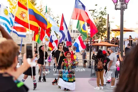 Participants walk among a display of Latin American flags at Mi Gente!